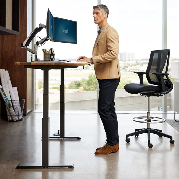 professional standing at electric standing desk in office setting