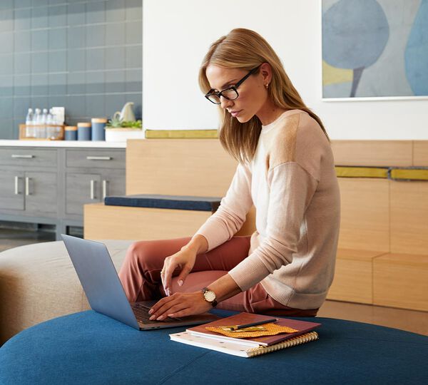 individual standing at an electric standing desk in a home office setting working