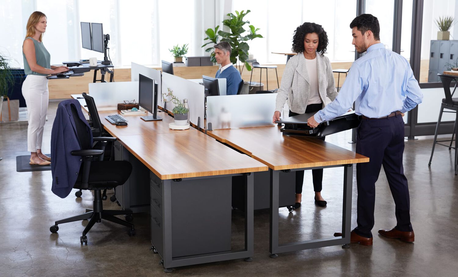 varidesk desktop converter being set in place on top of a fixed height desk