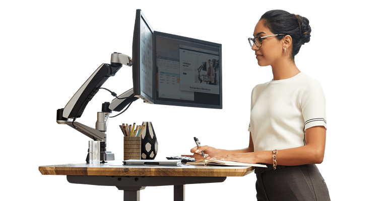 standing desk in use with dual monitor arms