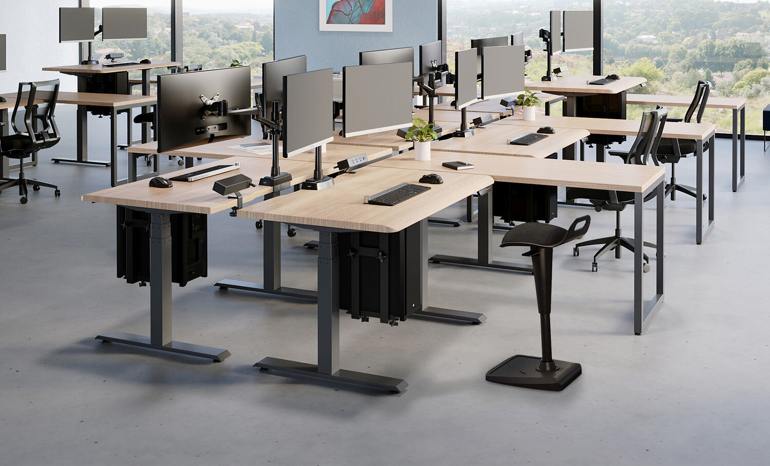 Modern open office with multiple workstations featuring light wood sit-stand desks, dual monitors, under-desk PC mounts, ergonomic chairs, and a scenic window view.