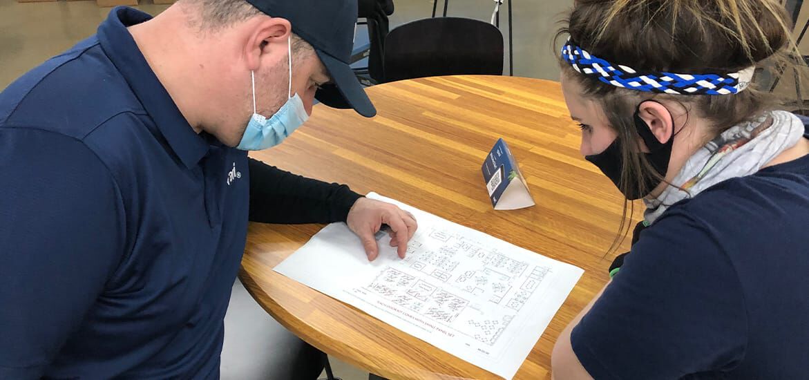 two vari employees wearing masks and reviewing a map. 