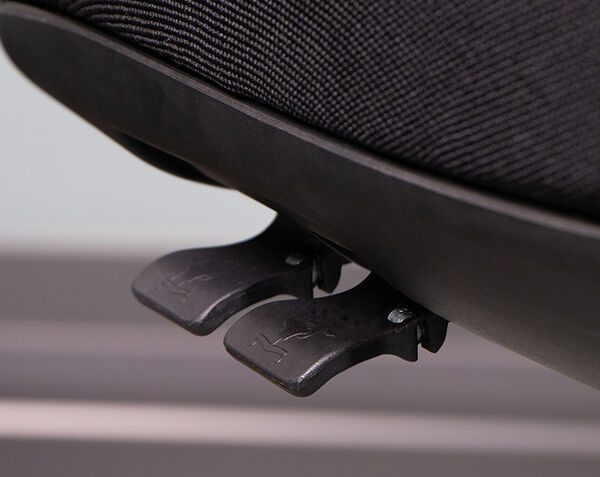 Close-up of two black lever controls beneath a chair seat, each embossed with a small leaping animal logo.