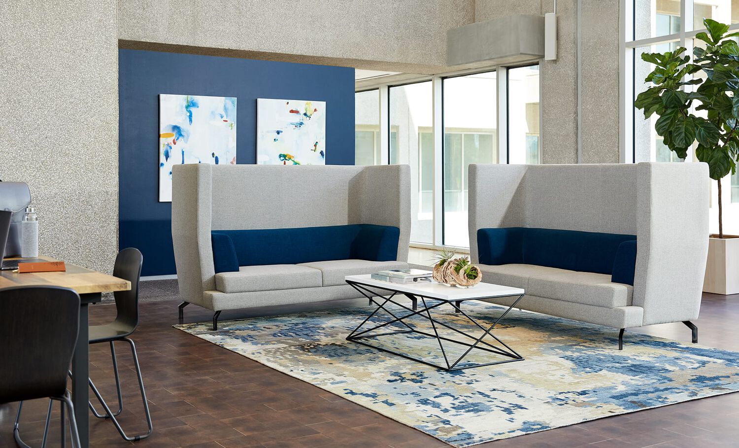2 high back sofas and a lounge table create a private meeting space 