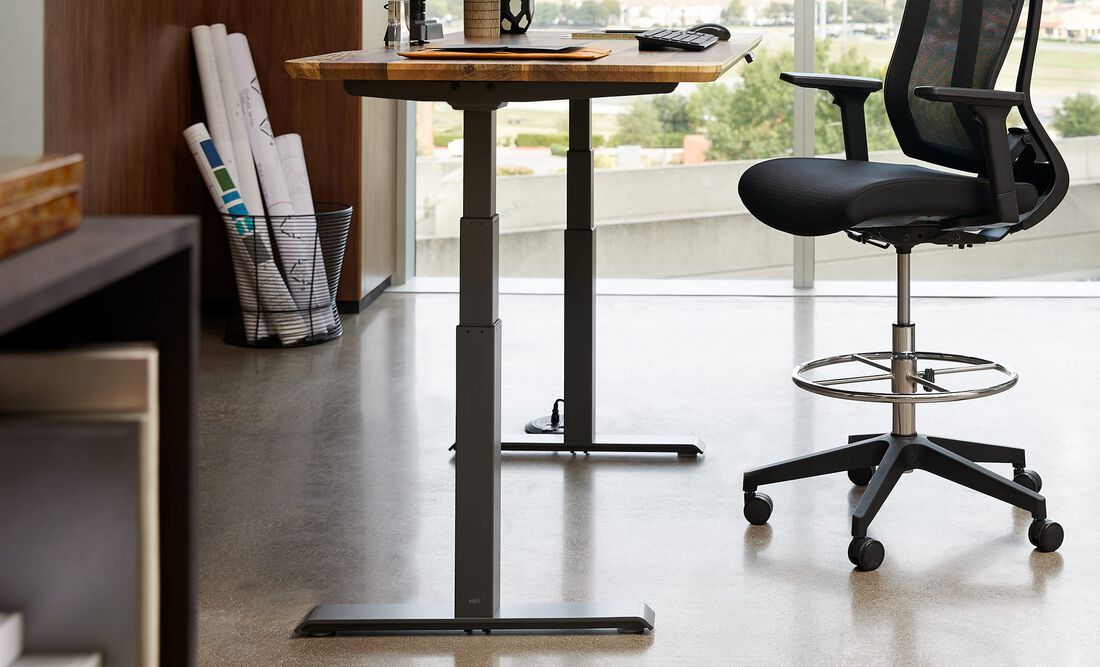 Electric standing desk in raised position in corporate office setting 