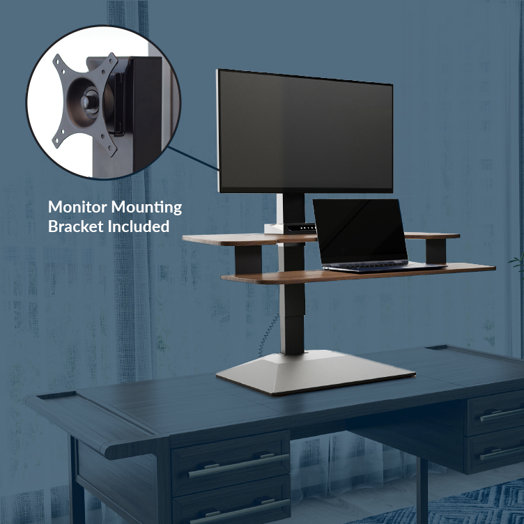 professional seated on active seat and working on electric standing desk