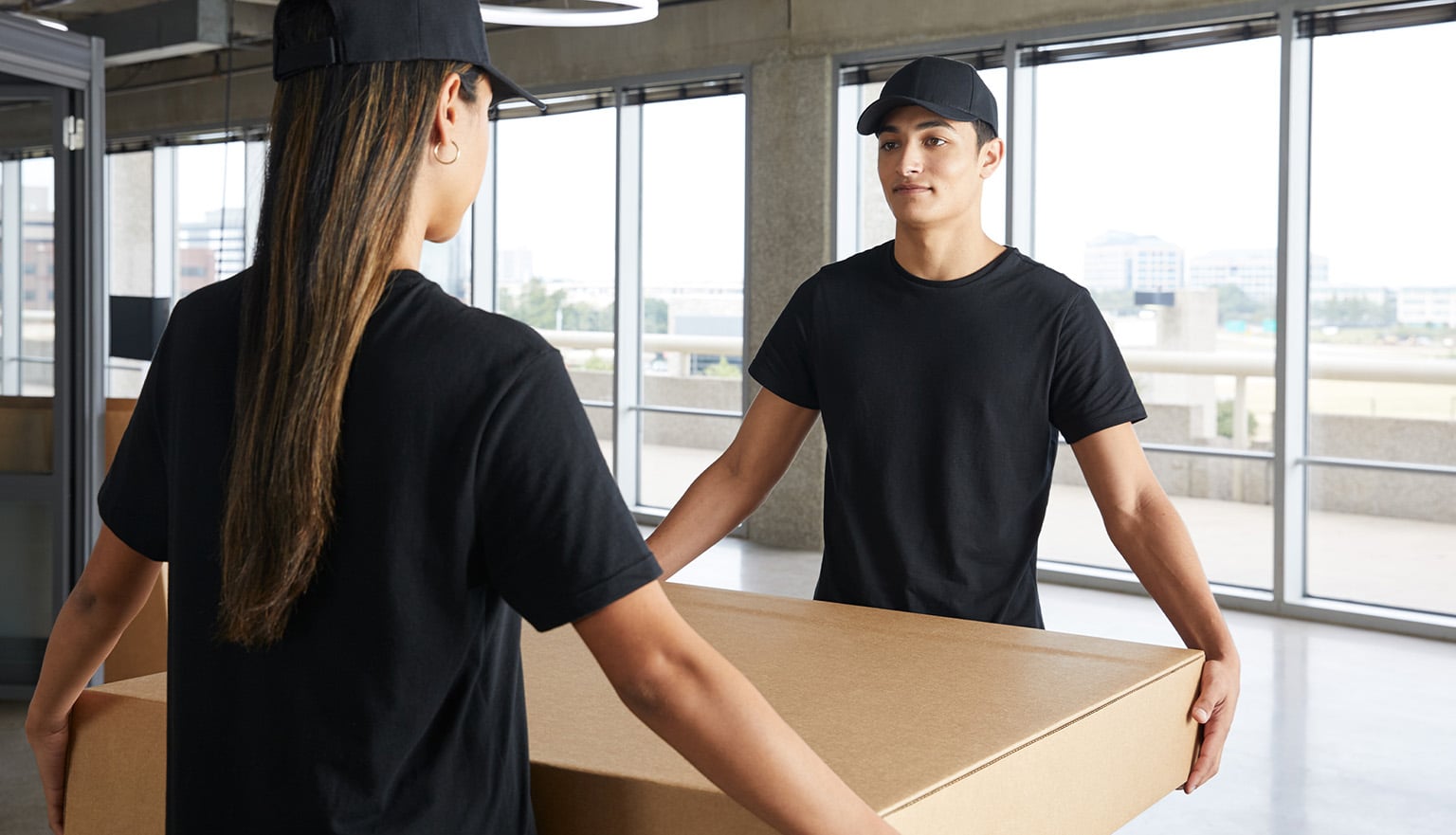 two professional installation workers carry a box