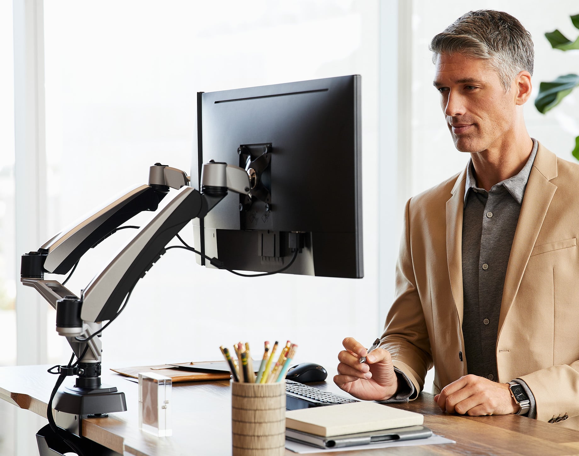 adjustable monitor arms hold computers high enough so that an office professional can comfortably use the computer