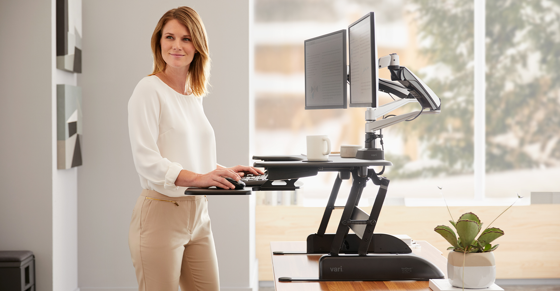 woman working at a raised standing desk converter