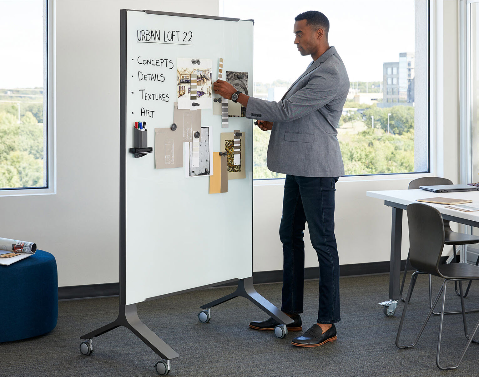 man writes on a markerboard to present data in a meeting