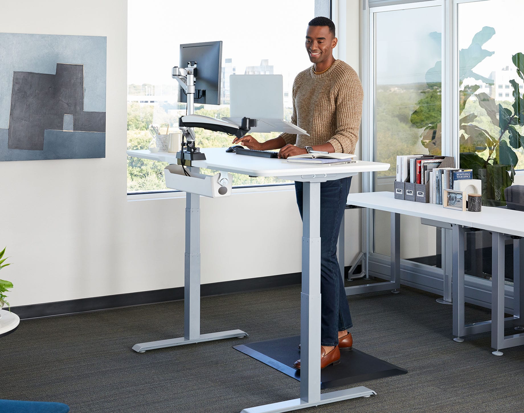 professional standing at vari electric standing desk in office setting