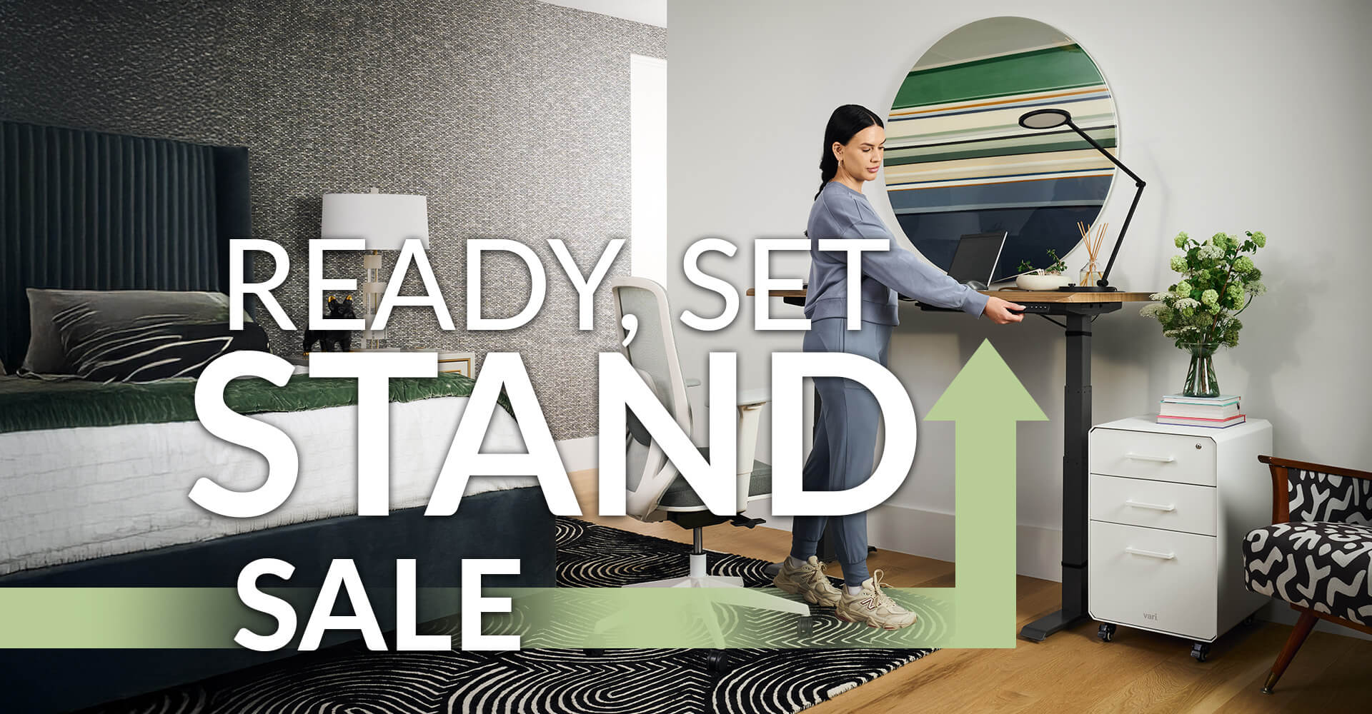 women standing at an electric standing desk and working in her home office