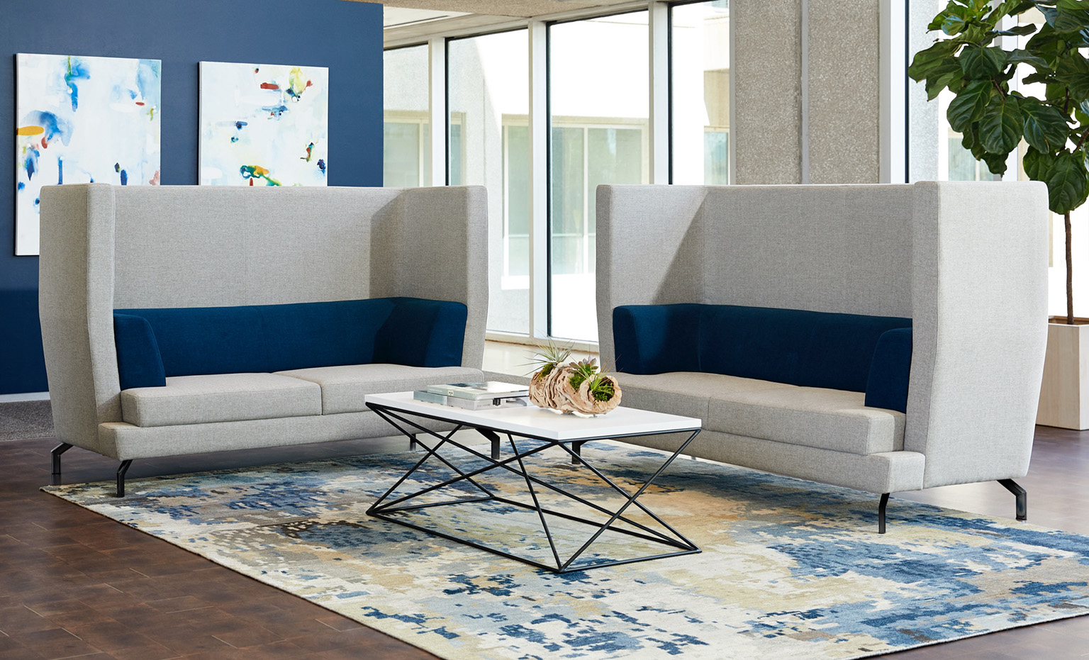 two high back sofas surround a coffee table in an office setting