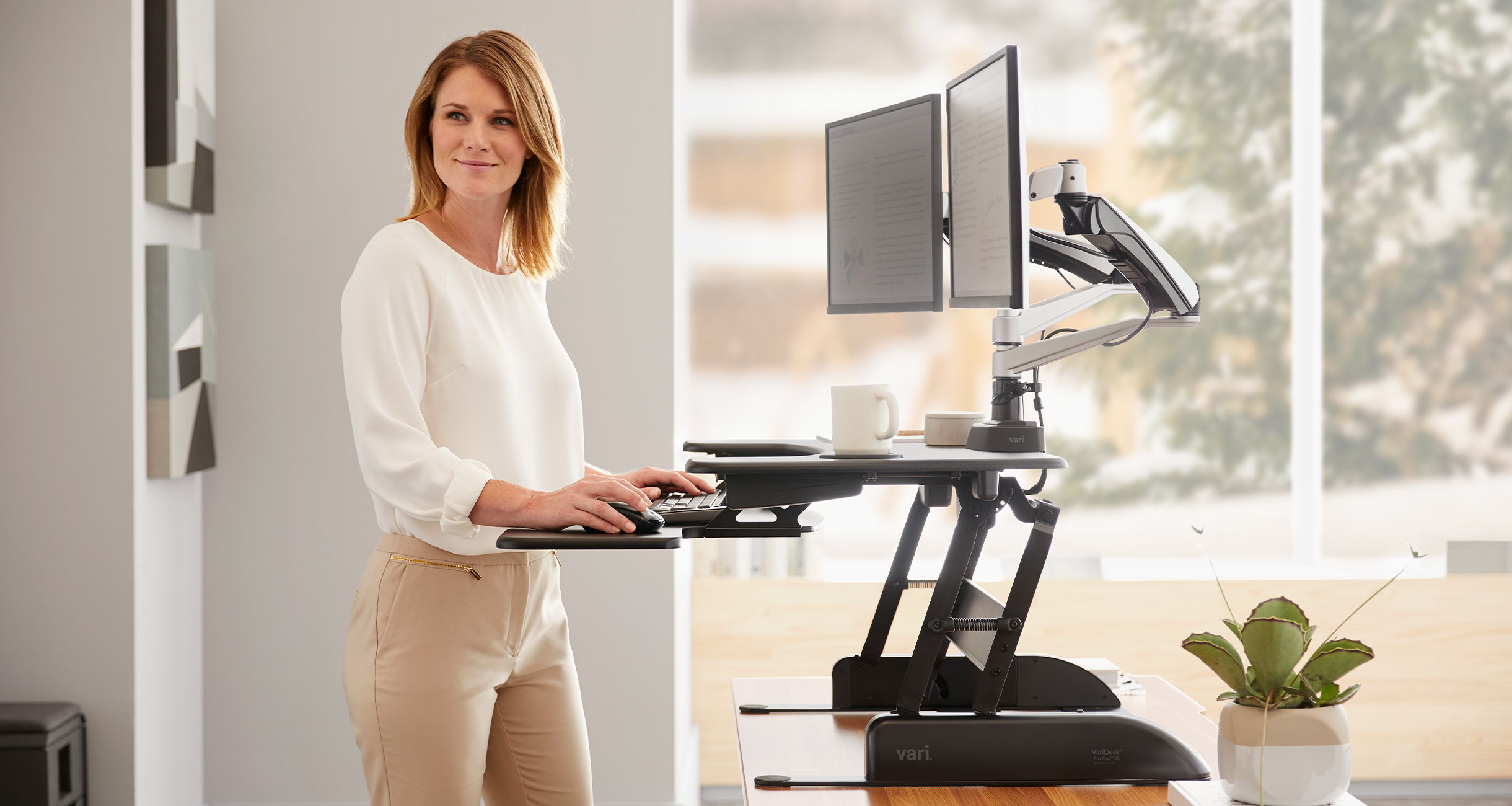 woman working at a raised standing desk converter