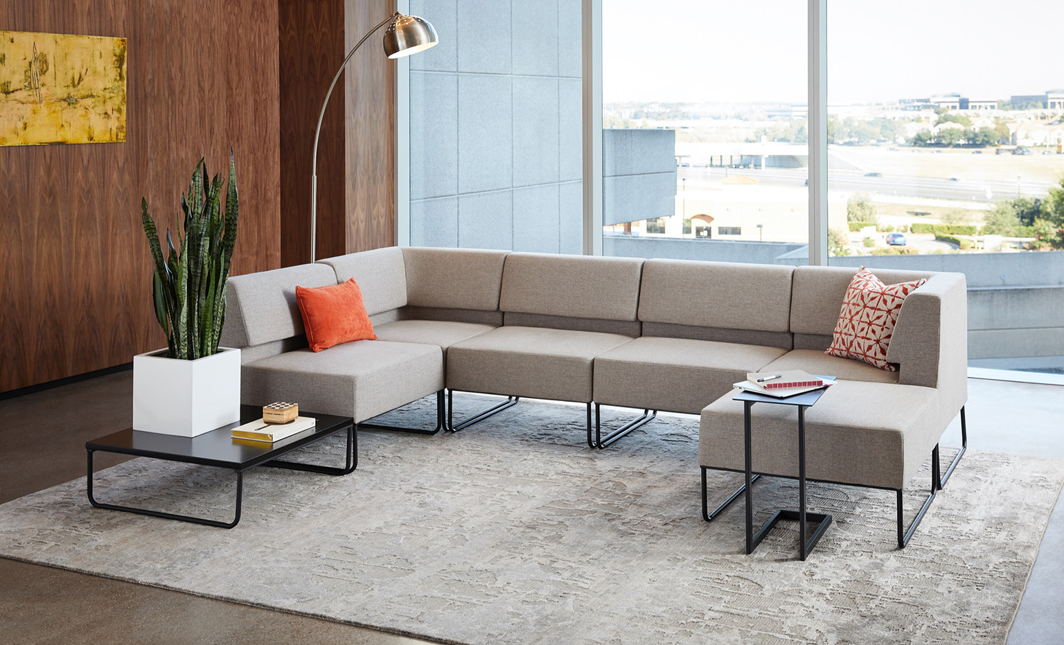 grey sectional sofa appears in office with variety of side and coffee tables