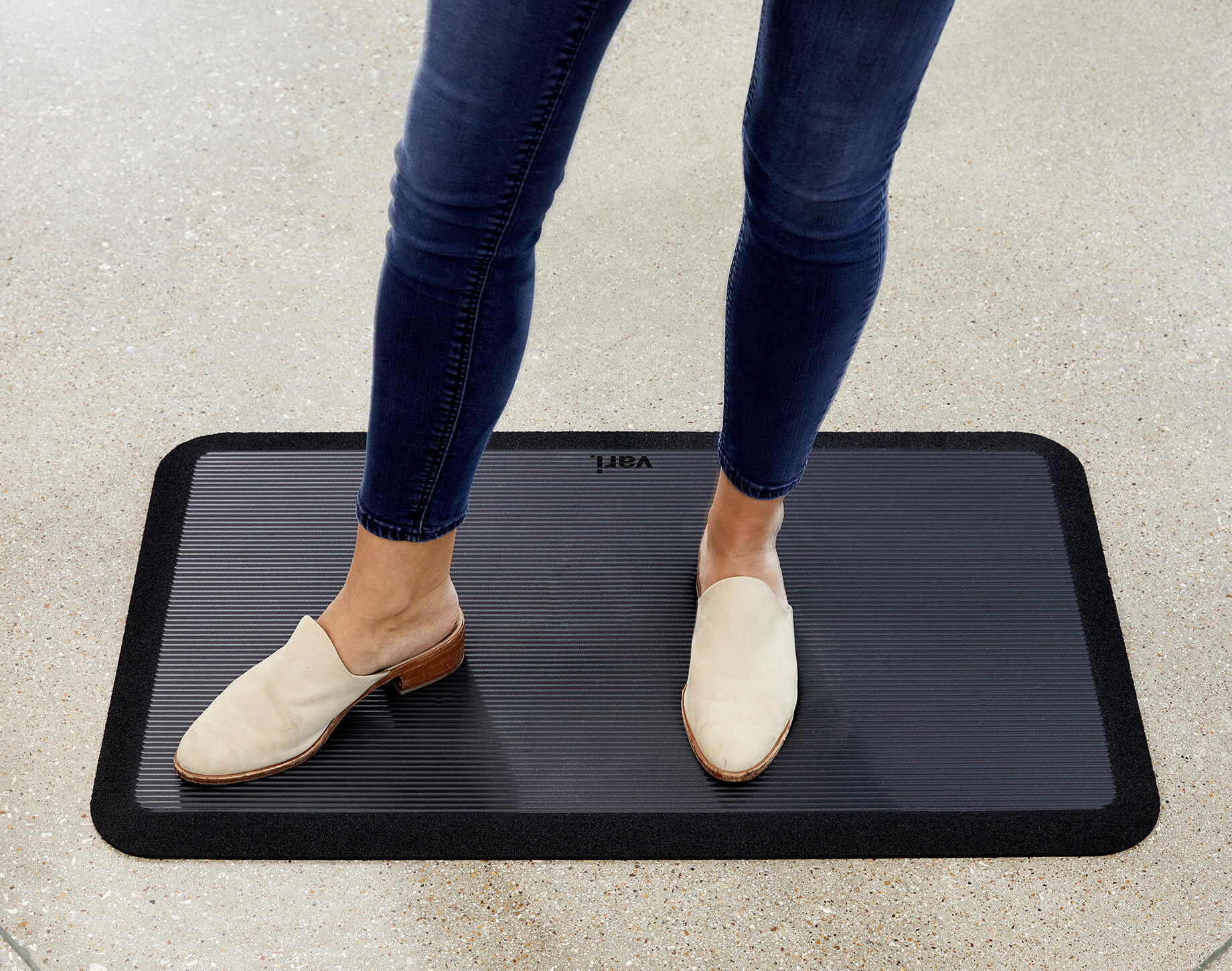 two feet on a standing mat in sneakers