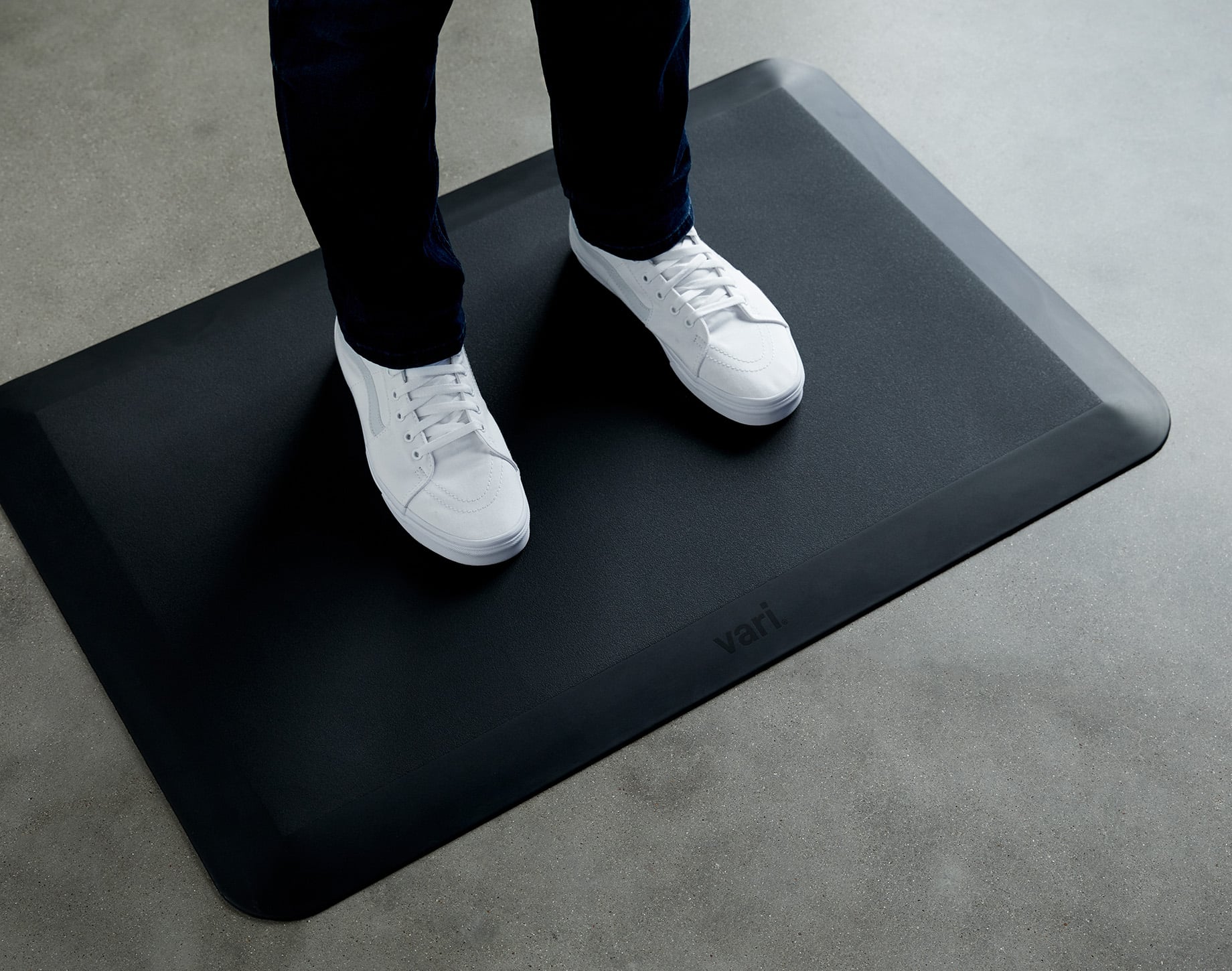 two feet on a standing mat in sneakers