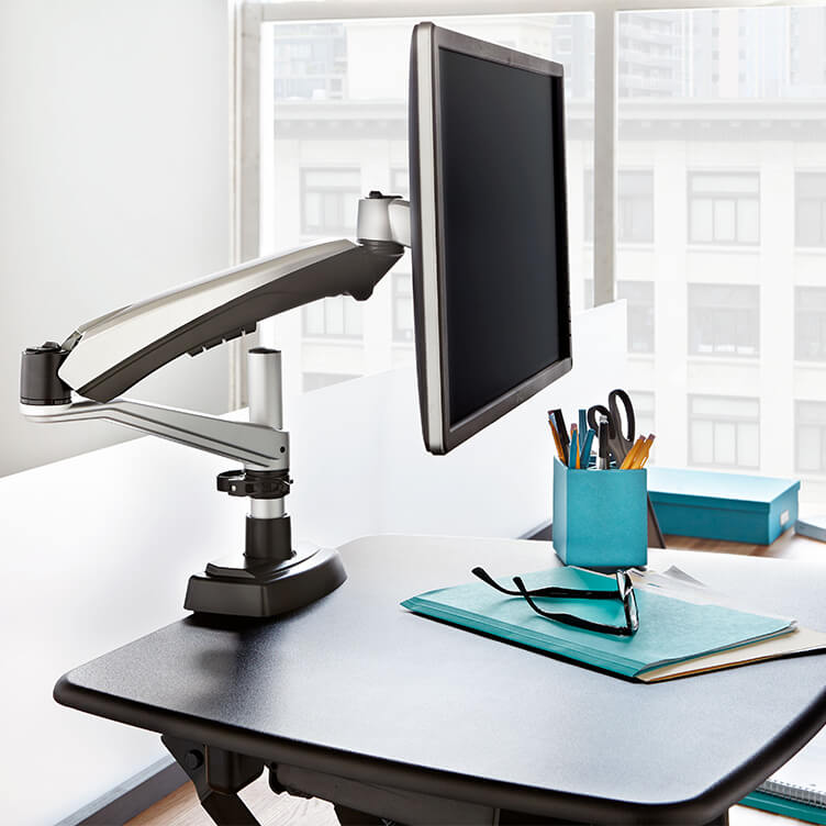 single monitor arm attached to a standing desk converter