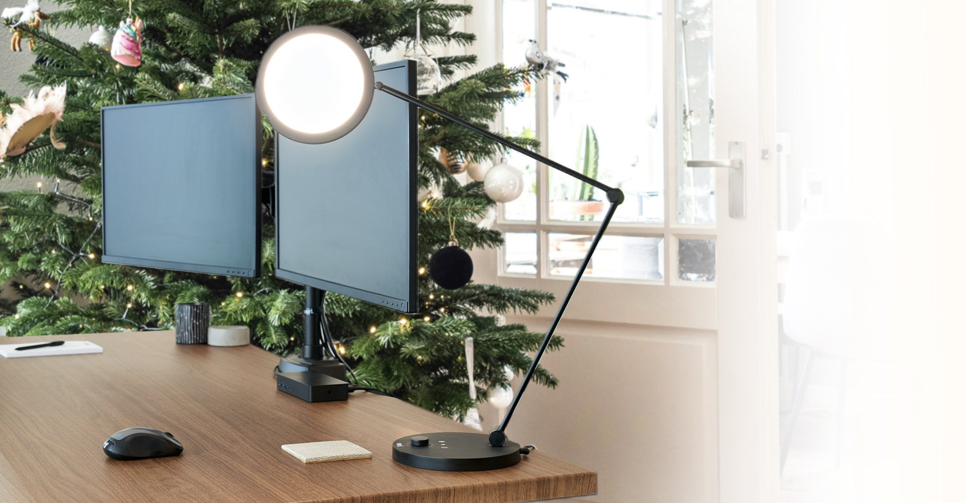 studio lamp on a desk with a christmas tree in the backgroun in a home office